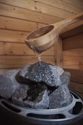 The hot steam from the water on the rocks of the sauna is good for health