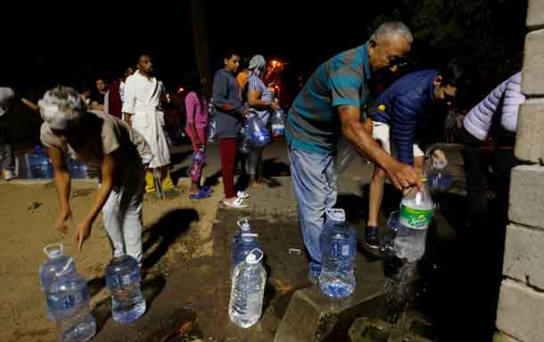 People queue to collect water from a spring in the Newlands suburb as fears over the city's water crisis grow in Cape Town, South Africa, January 25, 2018. Picture taken January 25, 2018. REUTERS/Mike Hutchings