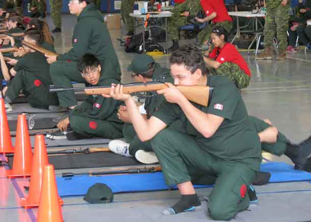 Junior Ranger Daniel Bottom shoots from a kneeling position.