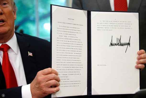 President Donald Trump displays an executive order on immigration policy after signing it in the Oval Office at the White House in Washington, U.S., June 20, 2018. REUTERS/Leah Millis
