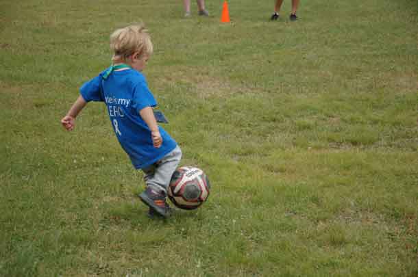 Camper Parker kicking his way into first base at our soccer/baseball game.