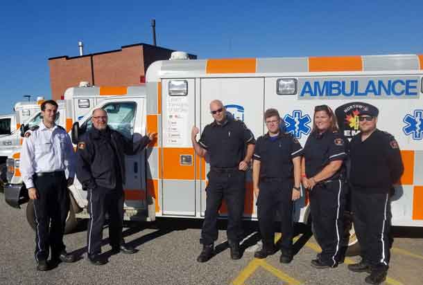 (From left to right) David Hamilton, Dennis Boyd, Ryan Larson, Jayson Sampson, Alyson English and Jarin Kilby of the Kenora District Services Board - Northwest Emergency Medical Services team point to the new FAST decal on one of their many ambulances.