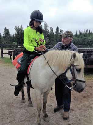 Junior Ranger Chasity Koosees of Kashechewan sits on a horse for the first time.