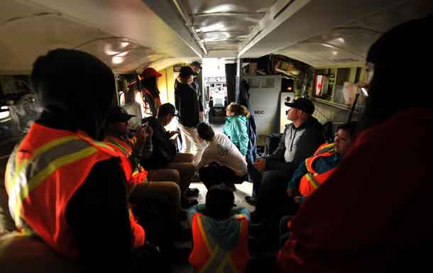 Storytime in the belly of a CL-415 Air Tanker. Stewardship Youth Rangers from the Dryden area listen to Co-Pilot Mike Towill describe his childhood fascination with water bombers and the goals he set in his youth to one day fly them. Photo: AFFES-Chris Marchand