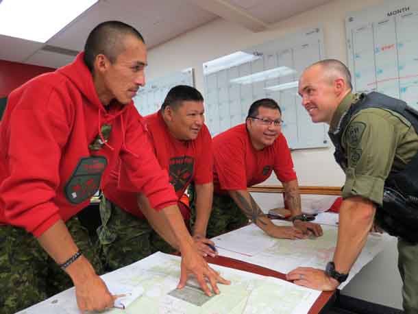 Ontario Provincial Police Constable Curtis Boychuk, right, reviews map reading points with Canadian Rangers during search and rescue training.
