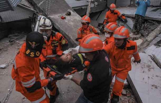 Search and rescue workers evacuate an earthquake and tsunami survivor trapped in a collapsed restaurant, Palu, Central Sulawesi, Indonesia September 30, 2018 in this photo taken by Antara Foto. Antara Foto/Muhammad Adimaja/ via REUTERS