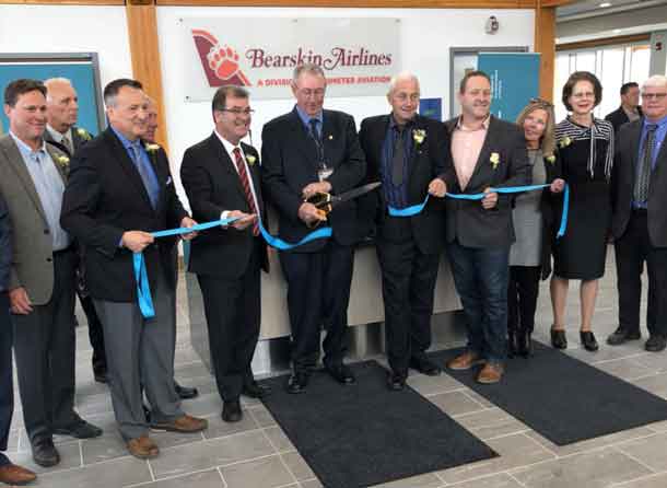Airport officials, dignitaries and elected leaders help cut the ribbon at the Kenora Airport