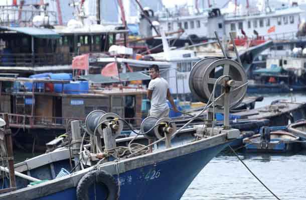 A fisherman anchors a boat at a fishing harbour, as Typhoon Mangkhut approaches, in Shenzhen, China September 15, 2018. REUTERS/Jason Lee