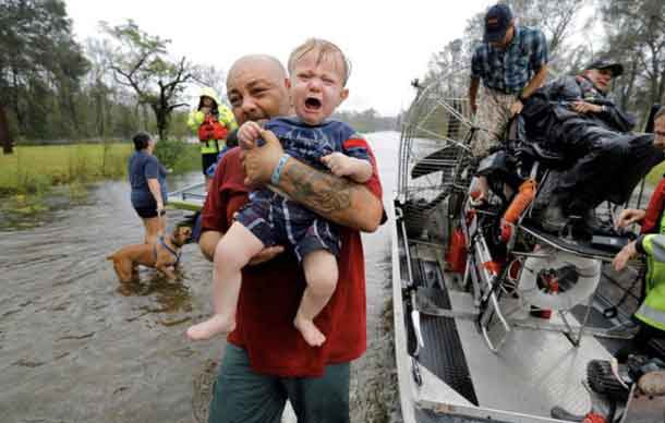 Oliver Kelly, 1 year old, cries as he is carried off the sheriff's airboat during his rescue from rising flood waters in the aftermath of Hurricane Florence in Leland, North Carolina, U.S., September 16, 2018. REUTERS/Jonathan Drake