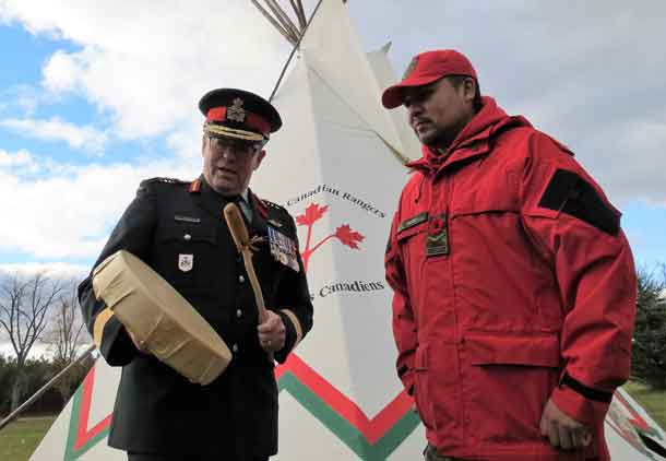Brigadier-General Jocelyn Paul uses Ranger Howard Jacob's drum to sing a song from his boyhood while growing up on the Huron-Wendat First Nation. Photo by Sgt Peter Moon