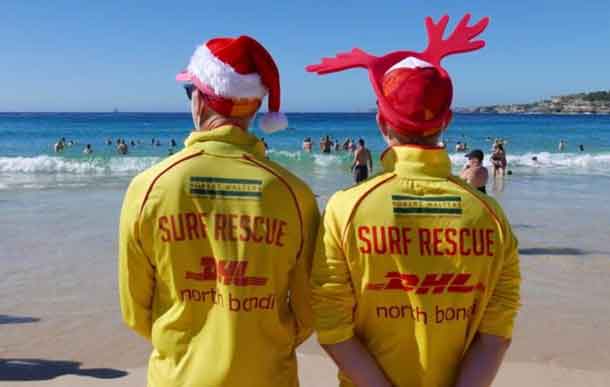 Simon (L) and Victor (R), volunteer life guards from North Bondi Surf Life Saving Club, keep an eye on swimmers enjoying Christmas day on Bondi Beach, Sydney, Australia, December 25, 2018. REUTERS/Jill Gralow