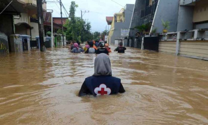 A volunteer wades through floods at a residential area in Makassar, South Sulawesi, Indonesia, January 23, 2019 in this photo taken by Antara Foto. Picture taken January 23, 2019. Antara Foto/Sahrul Manda Tikupadang/ via REUTERS