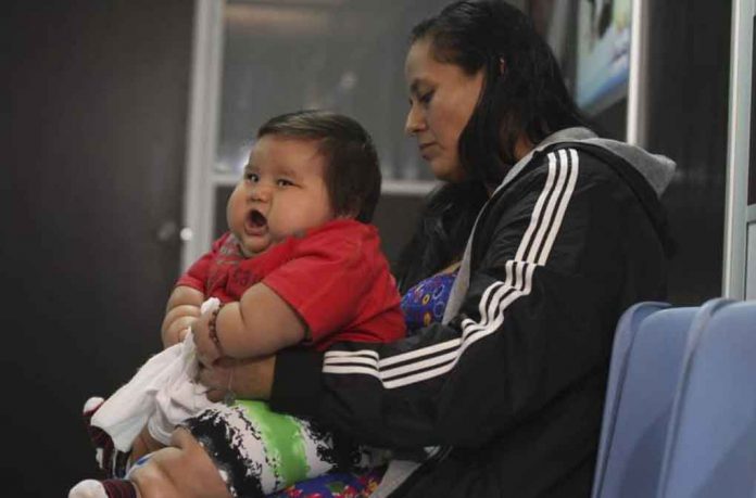 ARCHIVE PHOTO: Eight-month-old Santiago Mendoza waits with his mother Eunice Fandino at a clinic for the obese in Bogota March 19, 2014. REUTERS/John Vizcaino