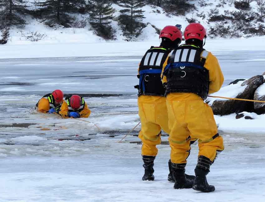 Soldiers haul a victim and his rescuer from broken ice - image: Sgt Peter Moon