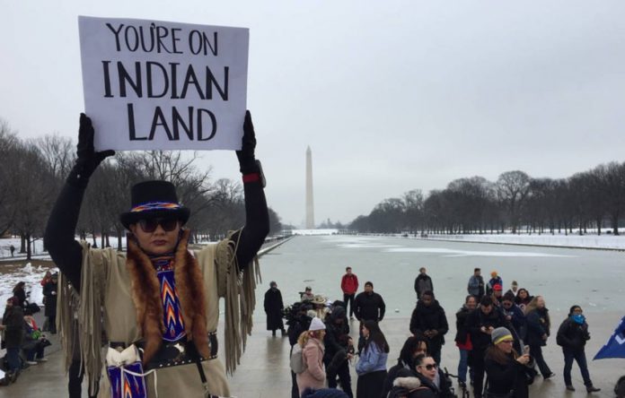 A participant holds a placard during the Indigenous Peoples March at the Lincoln Memorial in Washington, D.C., on Jan. 18, 2019. Thomson Reuters Foundation/Carey L. Biron