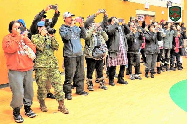 Relatives and friends take pictures during the graduation parade for new Canadian Rangers in Pikangikum.