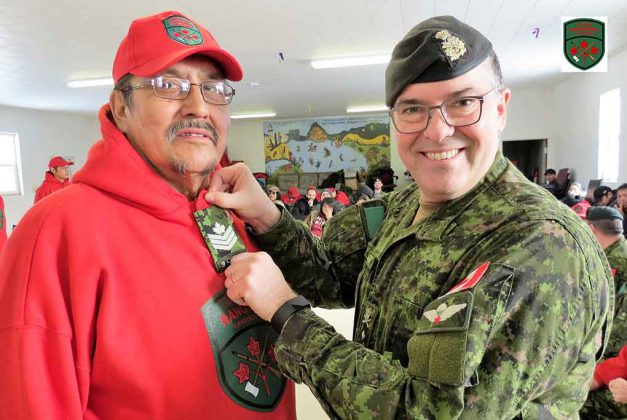 Newly appointed Sergeant Charles Wesley receives his rank insignia from Brigadier-General Jocelyn Paul in Cat Lake.