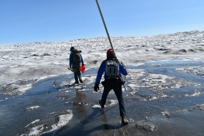 Increasing rainfall over the Greenland ice sheet is driving rapid melting of the surface. Here, researchers cross Greenland's Russell Glacier, July 2018. CREDIT: Kevin Krajick/Earth Institute