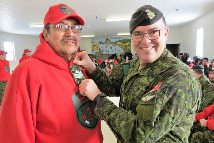 Sergeant Charles Wesley receives his rank insignia from Brigadier-General Jocelyn Paul, commander of the Canadian Army's 4th Canadian Division, at the opening of the new Cat Lake Canadian Ranger patrol in February.