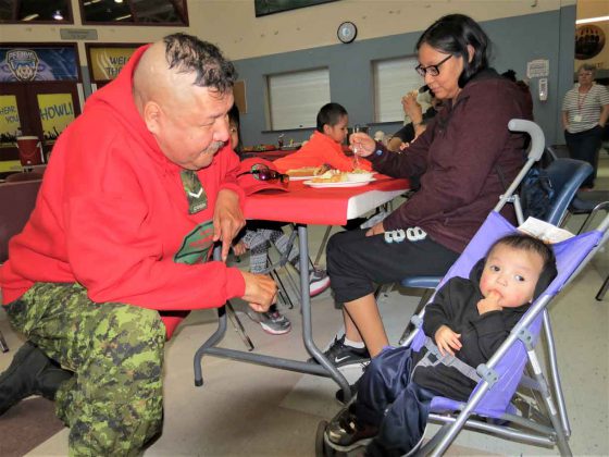 Ranger Rodney Rate plays with one-year-old Landon Quill at Pelican Falls First Nations School.