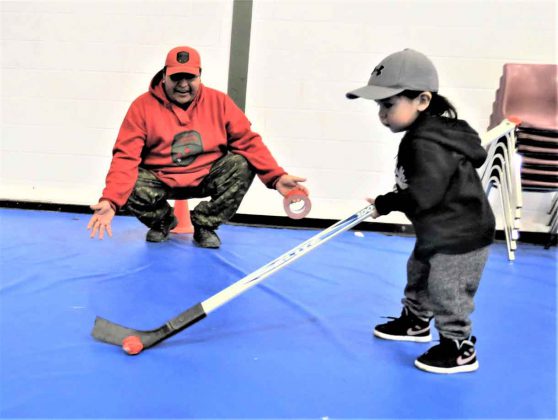 Ranger Freeman Ningewance plays with Pikangikum evacuee Manny Turtle, two, at Pelican Falls First Nation School