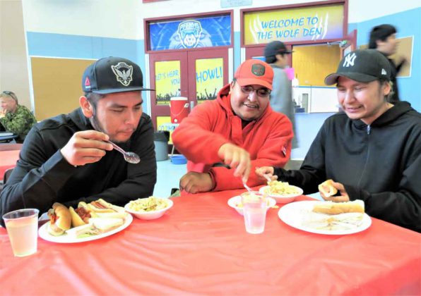 Ranger Freeman Ningewance, centre, talks with Pikangikum evacuees Adrian and Abraham Quill, who are brothers, at Pelican Falls First Nations School.