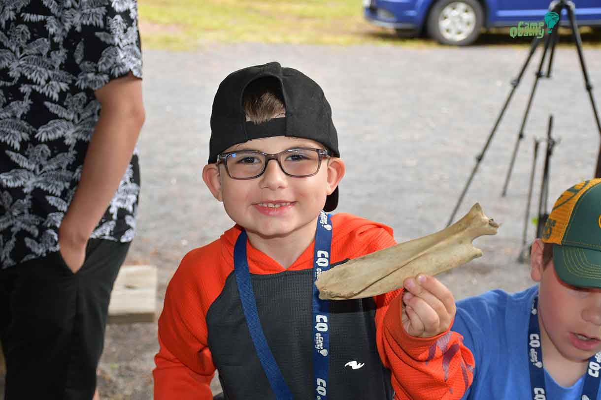 Camper Hunter showing off the fossil he found in the miniature fossil dig put on by Laura and Clarence from Lakehead University.