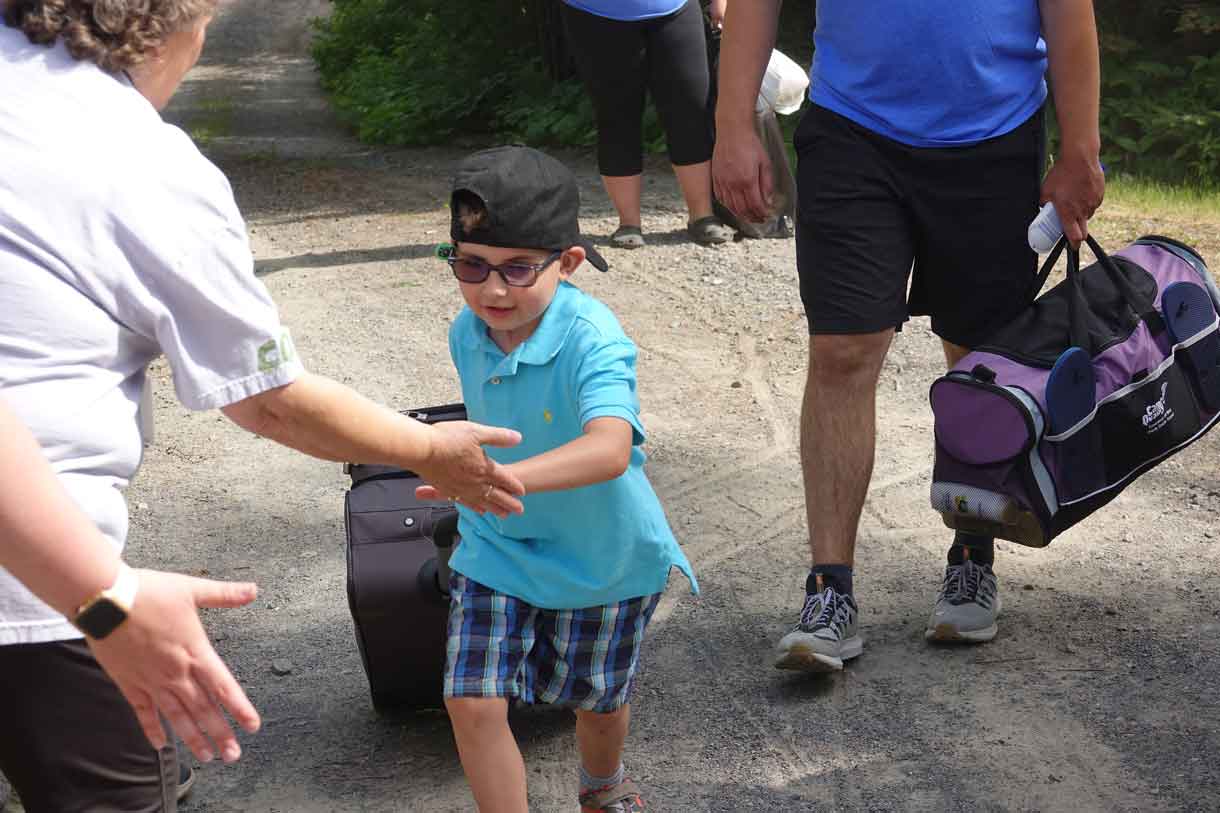 Camper Hunter receiving high fives as he hauls a suitcase double his size…he politely declined all offers of help.