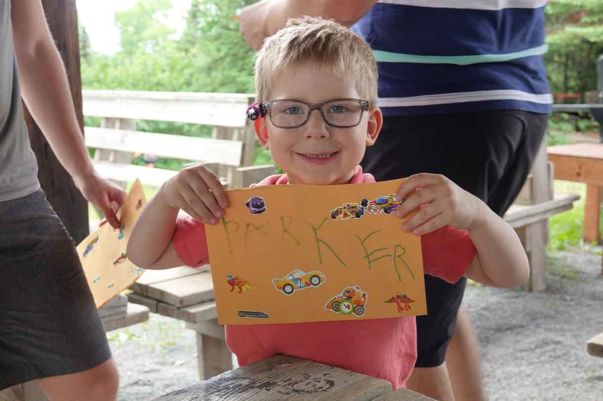 Camper Parker holding up his freshly decorated Q-Mail envelope.