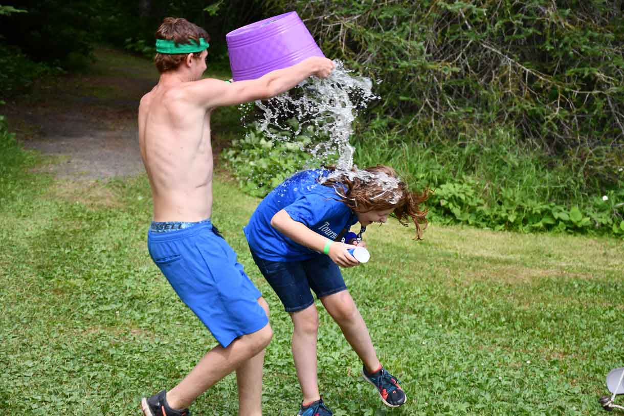 Camper Zeke dousing his sister Nevaya with the water that was SUPPOSED to be for the Survivor Challenge!