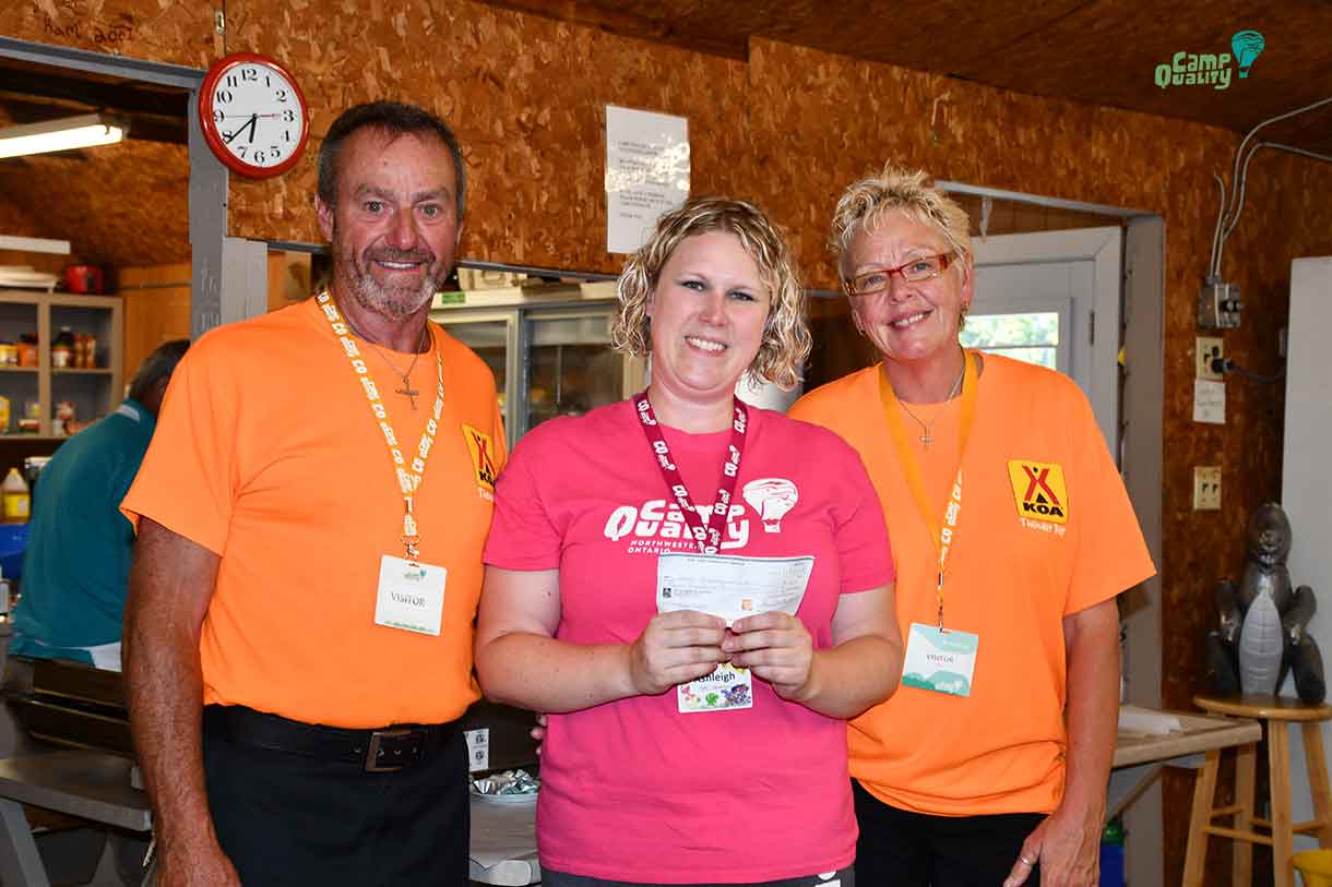 Mike (left) and Kristy (right) from KOA present Camp Director Ashleigh with a cheque $4000.