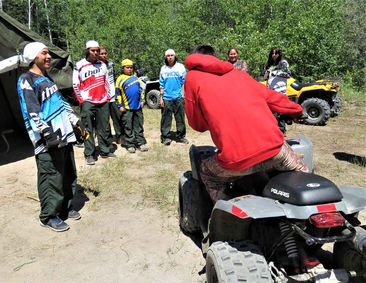 A Canadian Ranger shows Junior Canadian Ranger how to use their body weight to keep an ATV stable. Photo by Sgt Peter Moon Canadian Rangers