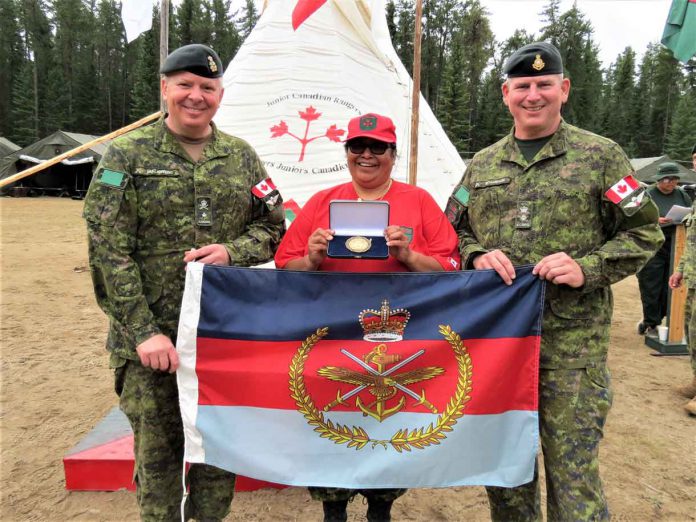 Brigadier-General Conrad Mialkowski, lzeft, commander of 4th Canadian Division, left, presents a Canadian Armed Forces Unit Commendation to 3rd Canadian Ranger Patrol Group for saving lives in Northern Ontario. The award consists of a pennant, a scroll, and a gold medallion. Master Corporal Harriet Cutfeet, centre, holds the medallion and Lieutenant-Colonel Matthew Richards, right, holds the pennant.