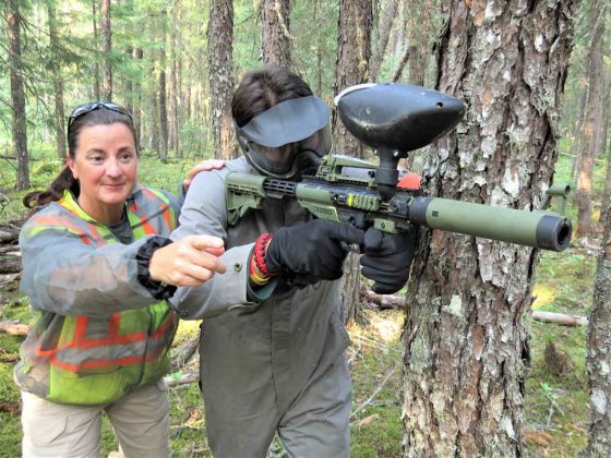 Constable Roxanne LeGrande guides Junior Canadian Ranger Wilbert Shisheesh on how to shoot on the paintball site. - Photo Sgt Peter Moon Canadian Rangers