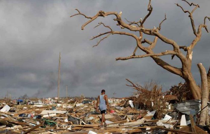 A man walks among debris at the Mudd neighborhood, devastated after Hurricane Dorian hit the Abaco Islands in Marsh Harbour, Bahamas, September 6, 2019. REUTERS/Marco Bello