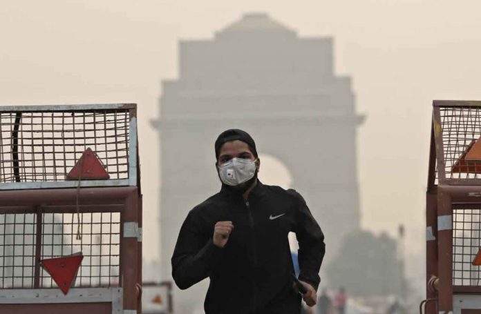 A man wearing a mask runs past the India Gate on a smoggy morning in New Delhi, India, October 28, 2019 REUTERS/Adnan Abidi