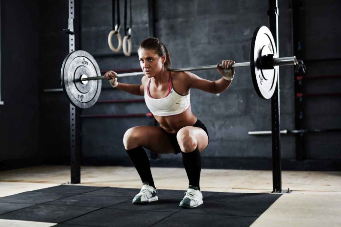Active young woman lifting weights