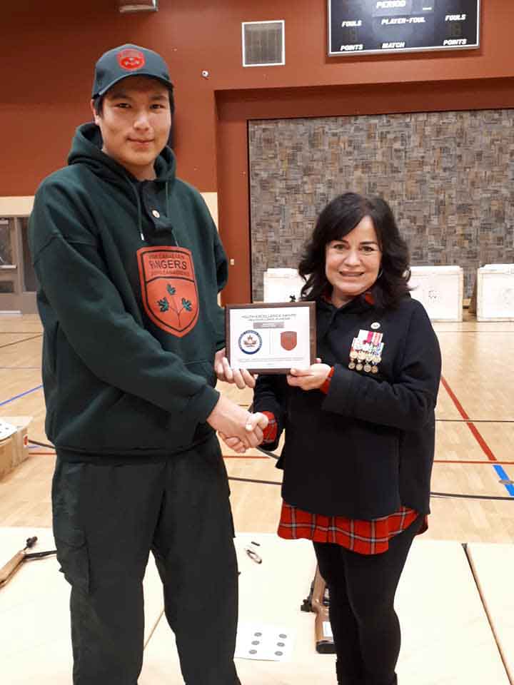 Junior Canadian Ranger Ian Kakekaspan receives a plaque and cheque from Kerry Vance, a director of Canada Company. Photo Credit - Corporal Lori Kendall, Canadian Rangers