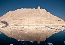 Greenland Ice Loss Seven Times Faster than in 1990s The midnight sun casts a golden glow on an iceberg and its reflection in Disko Bay, Greenland. Much of Greenland's annual mass loss occurs through calving of icebergs such as this. - CREDIT Ian Joughin, University of Washington