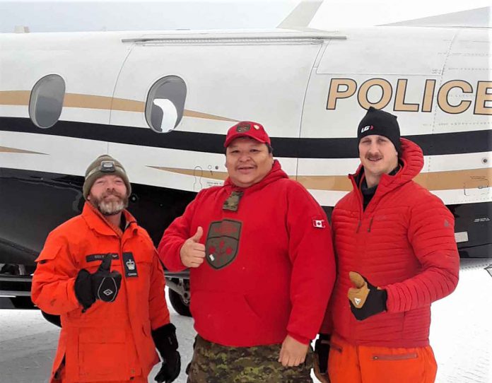 Sergeant Spenser Anderson, of the Canadian Rangers, centre, with two RCAF search and rescue technicians who played a key role in the rescue of the shot hunter.