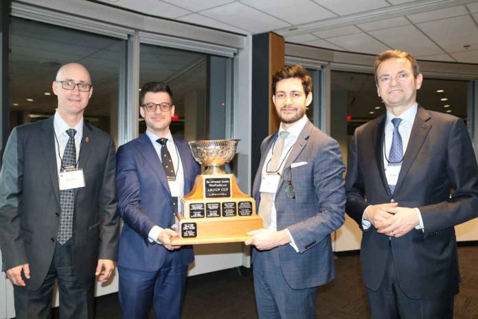 Justis Danto-Clancy, second from left, and Justin Blanco, third from left, were presented with the Arnup Cup by the Hon. Justice Clayton Conlan, left, and the Advocates’ Society’s President Scott Maidment.