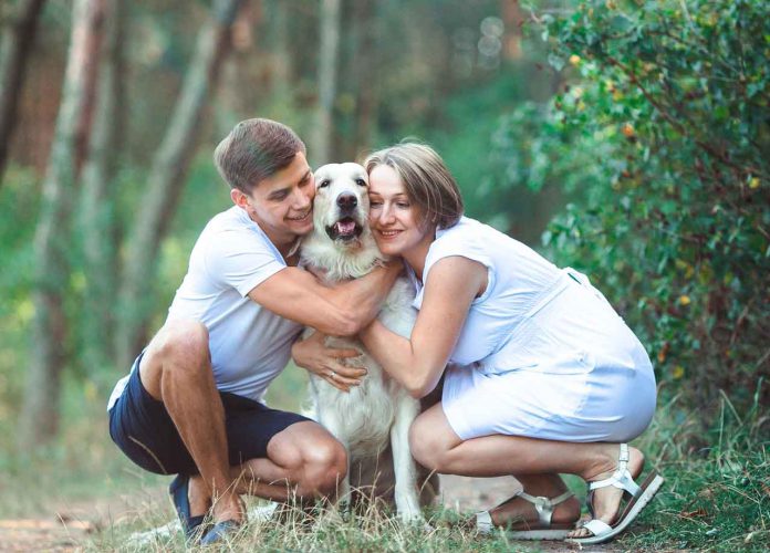 Happy couple with pet in the park