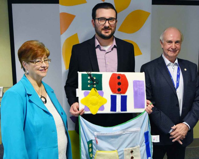 Matthew Shonosky (centre), Manager of the HELP program, showing samples of the Alzheimer's/Dementia activity items funded by a Family CARE grant, alongside Shirley Wragg (L), Vice President of the Volunteer Association and Barry Streib (R), Secretary and Chair, Governance for the Thunder Bay Regional Health Sciences Foundation