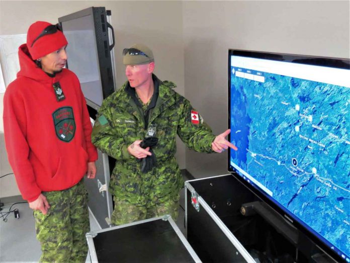 Corporal Earl Wesley of Long Lake # 58 First Nation, left, checks patrol routes on a map with Warrant Officer Christopher Thomson, an army instructor.