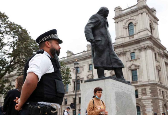 A police officer stands next to the statue of Winston Churchill at Parliament Square which was damaged by protesters with graffiti, in the aftermath of protests against the death of George Floyd who died in police custody in Minneapolis, London, Britain, June 8, 2020. REUTERS/John Sibley