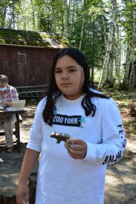 photo by Faye Naveau  Mishlynne Batisse, 11 year old youth participants displays her soap stone craftwork at the Wabun Youth Gathering at Dorothy Lake.