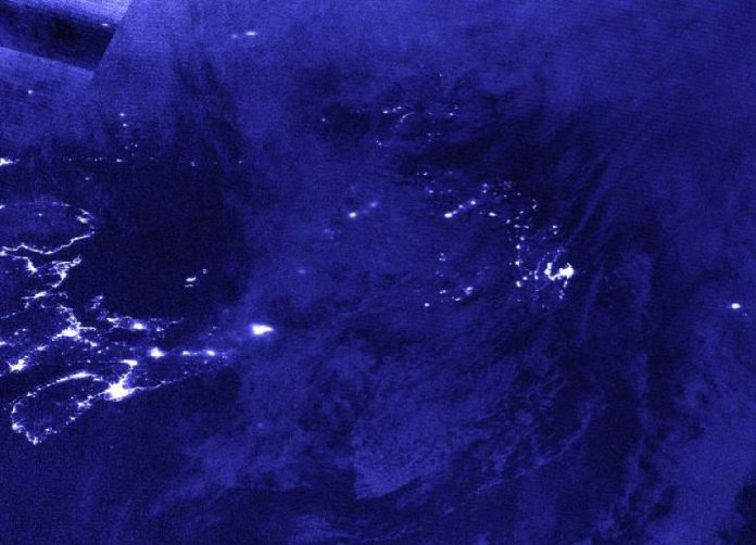 NASA-NOAA's Suomi NPP satellite provided a nighttime view of Post-Tropical Cyclone Teddy over Newfoundland, Canada at 1:40 a.m. EDT (0540 UTC) on Sept. 24. The nighttime lights of Newfoundland can be seen somewhat through Teddy's clouds, and the nighttime lights of Nova Scotia were visible, revealing the Teddy had moved past the province. CREDIT: NASA Worldview, Earth Observing System Data and Information System (EOSDIS)