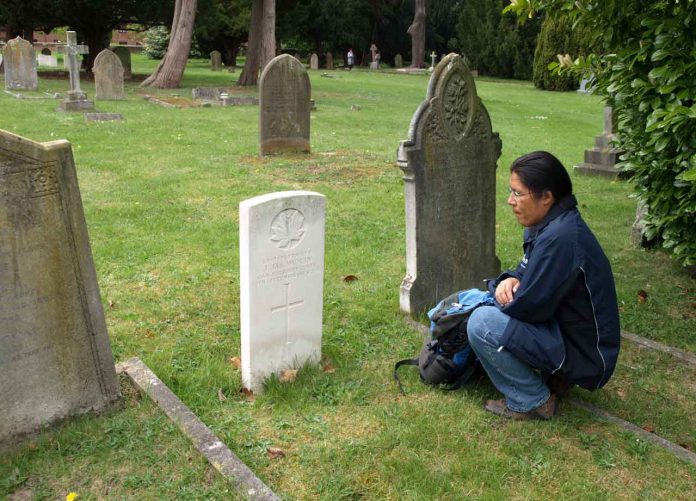 John Chookomolin's final resting place is in St Jude's Cemetery in Englefield Green, UK, a small community on the outskirts of the city of London, England. Here we see Xavier Kataquapit at the grave of his great grandfather during a visit to England.