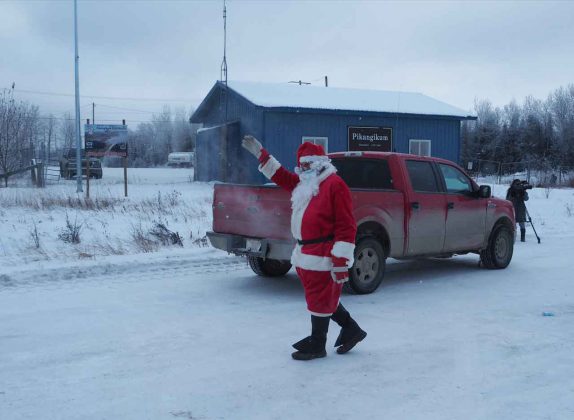 Santa waves at the people from the safety of the tarmac at the Pikangikum Airport