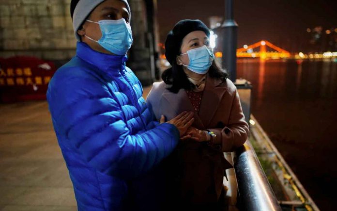 Fang Yushun warms the hands of his wife, Duan Ling, 36, during a cold winter’s night as they take a walk outside, almost a year after the global outbreak of the coronavirus disease (COVID-19) in Wuhan, Hubei province, China December 16, 2020. REUTERS/Aly Song